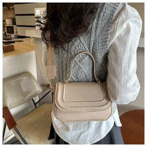Chic apricot PU crossbody bag with U-shaped stitching and wide strap in cafe setting