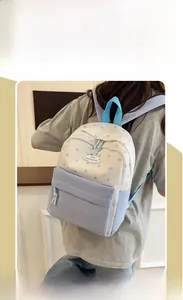 Vue latérale du sac à dos scolaire avec motifs d'étoiles bleues et détails de fermeture nouée