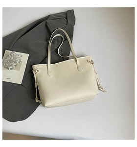 Macro detail of cream leather tote bag featuring adjustable drawstring and soft matte finish