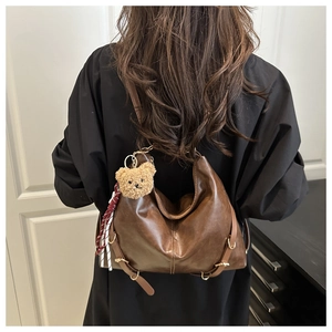 Détail du sac hobo marron vintage avec pendentif ours en peluche et ruban rayé