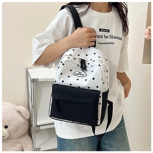 Détail du sac à dos en toile à motif d'étoiles avec poche avant et bretelles noires