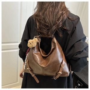 Détail du sac cabas en cuir marron foncé montrant sa grande capacité et sa bandoulière réglable