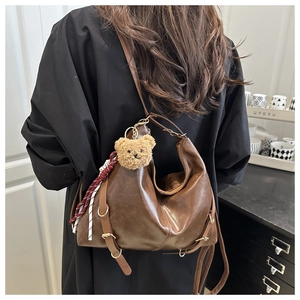Vue détaillée du sac hobo rétro en similicuir marron avec breloque ours et bandoulière