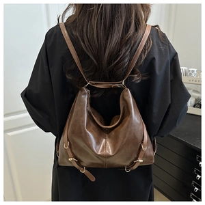 Détail d'un sac à dos hobo vintage en similicuir marron foncé avec ferrures dorées