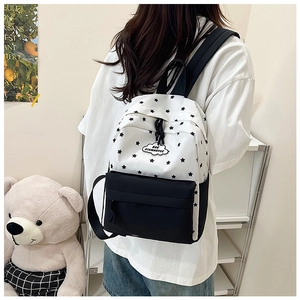 Détail du motif d'étoiles noires sur sac à dos blanc avec poche latérale pour bouteille d'eau