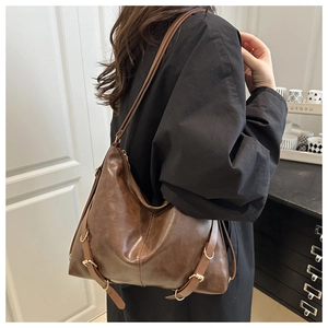 Détail du sac porté épaule vintage marron avec boucles métalliques et texture souple