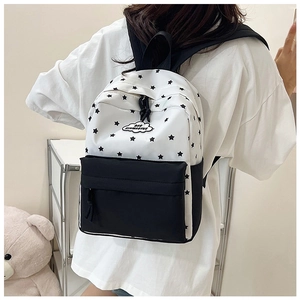 Détail d'un sac à dos imprimé d'étoiles noir et blanc avec un écusson de logo nuage