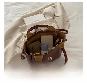Vue intérieure du sac seau marron foncé montrant l'espace pour portefeuille et mobile