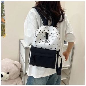 Détail du sac à dos en toile avec étoiles noires et écusson logo en forme de nuage