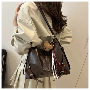 Détail du grand cabas en cuir marron avec texture cirée douce et breloque ours