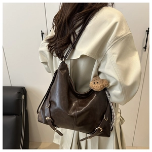 Détail du grand sac cabas marron foncé en cuir avec boucle vintage et breloque peluche