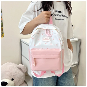 Détail de l'imprimé étoiles roses sur sac à dos en toile avec logo nuage et fermetures
