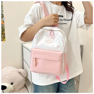 Détail du sac à dos scolaire rose et blanc avec motifs étoiles et tirettes tissées