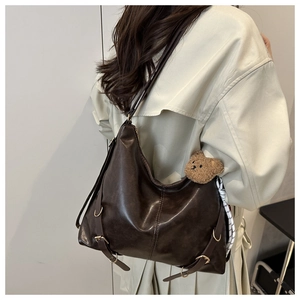 Détail du sac hobo chocolat brillant avec boucles réglables et breloque ourson