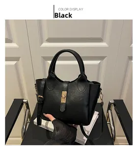 Détail du sac seau noir avec fermoir rotatif doré et poignée supérieure robuste