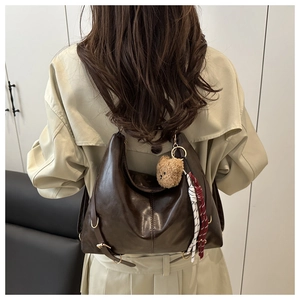 Détail du sac cabas vintage en cuir marron avec breloque ours et cordon décoratif