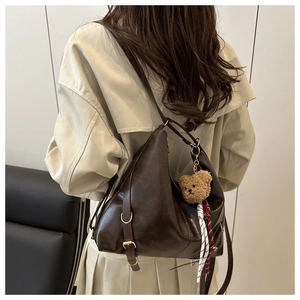 Détail du sac cabas en cuir souple avec bandoulière réglable et breloque ours sur modèle
