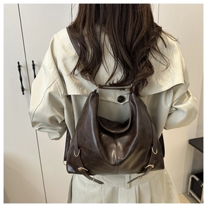 Détail du sac cabas en cuir marron foncé vintage avec boucles dorées et texture souple