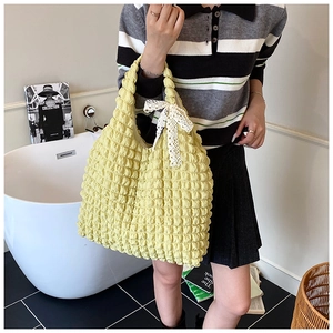 Close-up of pale yellow seersucker tote bag with a white lace bow detail