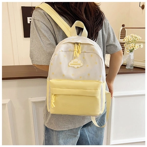 Gros plan du sac à dos en toile blanche avec motifs d'étoiles jaunes et logo en forme de nuage
