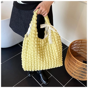 Detailed shot of yellow popcorn texture fabric tote bag with a white lace bow detail