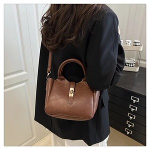 Détails du sac seau en cuir marron avec boucle métallique et logo FASHION gravé