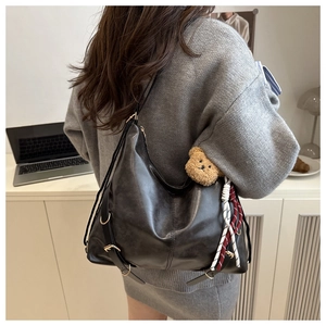 Détail d'un grand sac cabas en cuir noir avec boucles vintage et pendentif d'ours