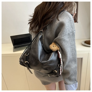 Détail du grand sac hobo noir avec boucles métalliques et pendentif ours mignon