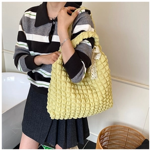 Detailed close-up of yellow bubble textured tote bag featuring a delicate white lace bow