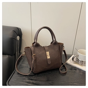 Détail du sac seau marron foncé avec texture litchi et boucle en métal doré chic