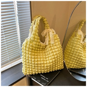 Detail of light yellow popcorn texture tote bag with delicate white lace bow decoration