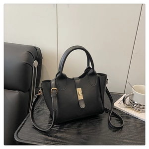 Détail du sac seau noir classique avec texture cuir litchi et fermoir en métal doré