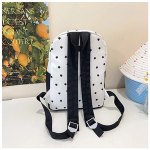 Détail d'un sac à dos blanc avec motifs d'étoiles noires et bretelles réglables