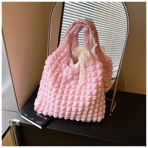 Detailed texture of pink bubble fabric bag with a white lace bow in a modern setting