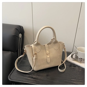Détail d'un sac seau blanc crème avec fermoir rotatif doré et bandoulière réglable