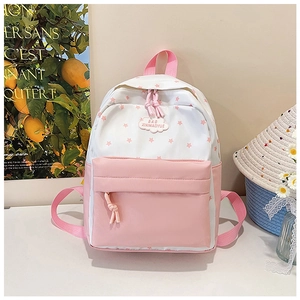 Détail d'un sac à dos rose à motif d'étoiles avec un écusson décoratif en forme de nuage