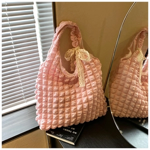 Detailed macro view of pink puffed bubble bag texture with beige lace bow decoration