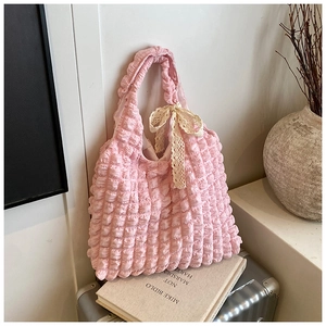 Pink popcorn fabric shoulder bag with a white lace bow detail on the handle