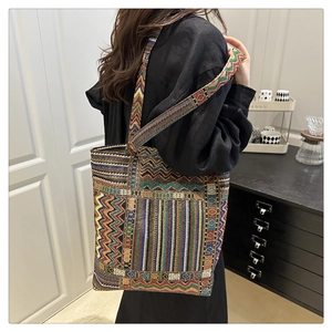 Close-up of Bohemian woven tote with colorful geometric patterns and long shoulder strap