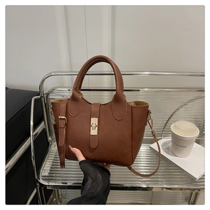 Gros plan détaillé d'un sac à main vintage marron avec fermoir doré et texture en cuir