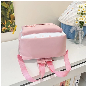 Détail du sac à dos scolaire rose et blanc avec motifs d'étoiles et bretelles rembourrées