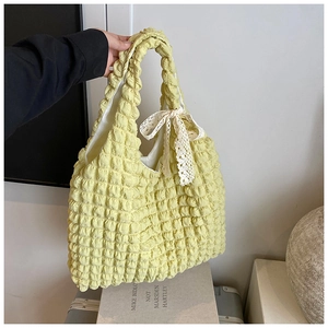 Detail of light yellow popcorn texture tote bag with a delicate white lace bow accent