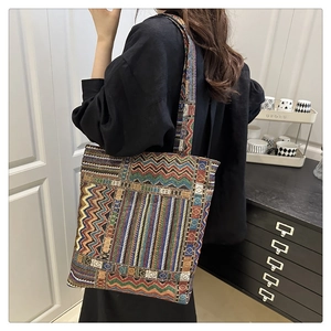 Detailed close-up of colorful ethnic knit tote bag with geometric wavy patterns