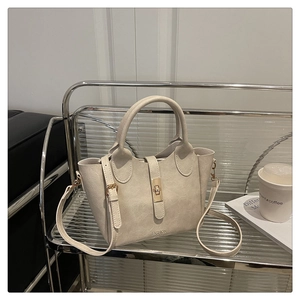 Détail d'un sac en similicuir crème avec boucle dorée et logo de mode élégant