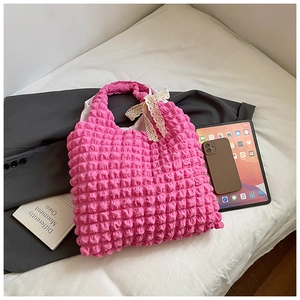 Pink bubble textured tote bag detail featuring a white lace bow and ruched fabric