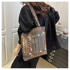 Detail shot of woman wearing a large tote bag with colorful geometric woven patterns