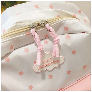 Détail de double fermeture éclair avec imprimé étoile rose et pendentif nuage sur sac