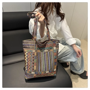 Détail d'un sac cabas ethnique aux motifs géométriques colorés posé sur un canapé