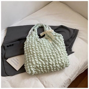 Detailed macro view of mint green bubble textured fabric tote with white lace bow decoration