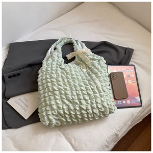 Detail of light green popcorn fabric tote bag with lace bow and spacious interior